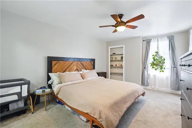a bedroom with a bed and a ceiling fan