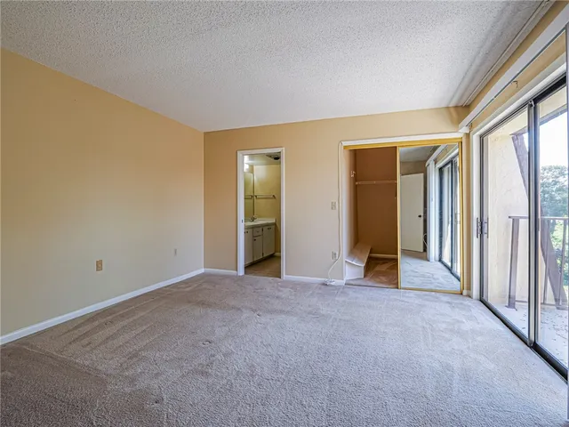 an empty room with closet and a large window