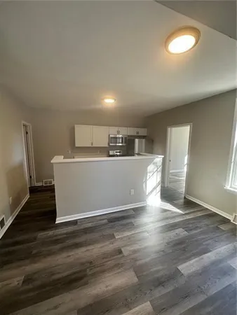 a view of a kitchen with furniture and wooden floor