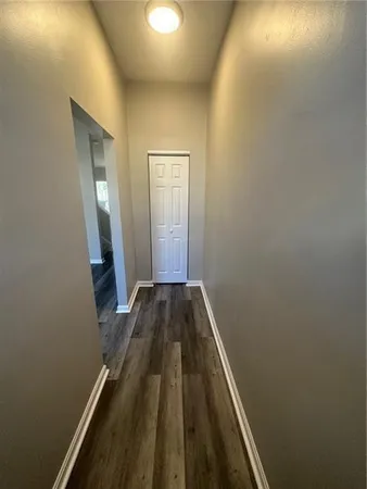 a view of a hallway with wooden floor