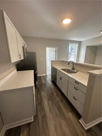 a kitchen with a sink a stove and cabinets