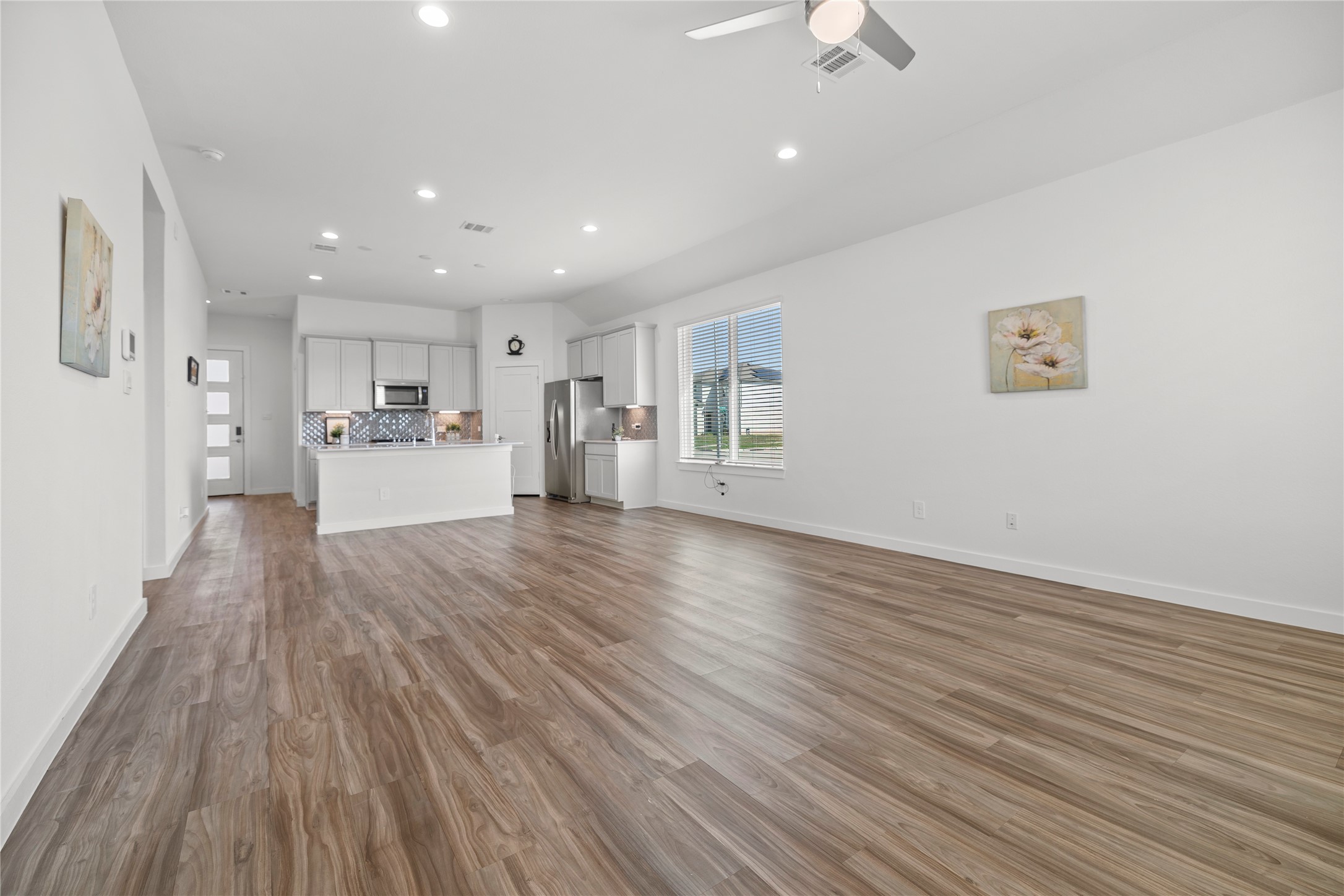 22803 Modica Rift Lane Katy, TX 77449 - Photo 14 of 30 a view of empty room with wooden floor and kitchen