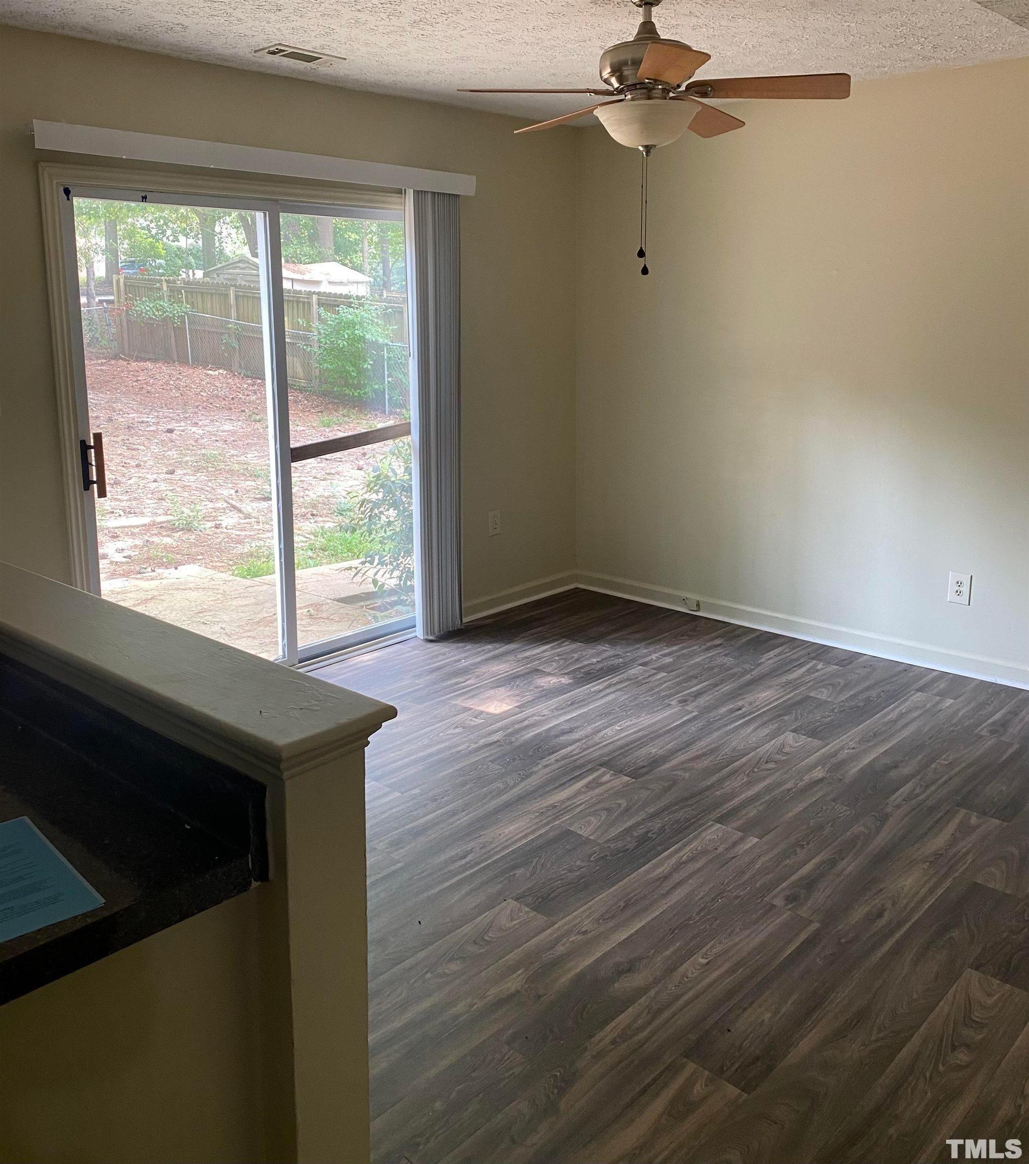 2801 Henslowe Drive Raleigh, NC 27603 - Photo 5 of 17 an empty room with wooden floor fan and windows