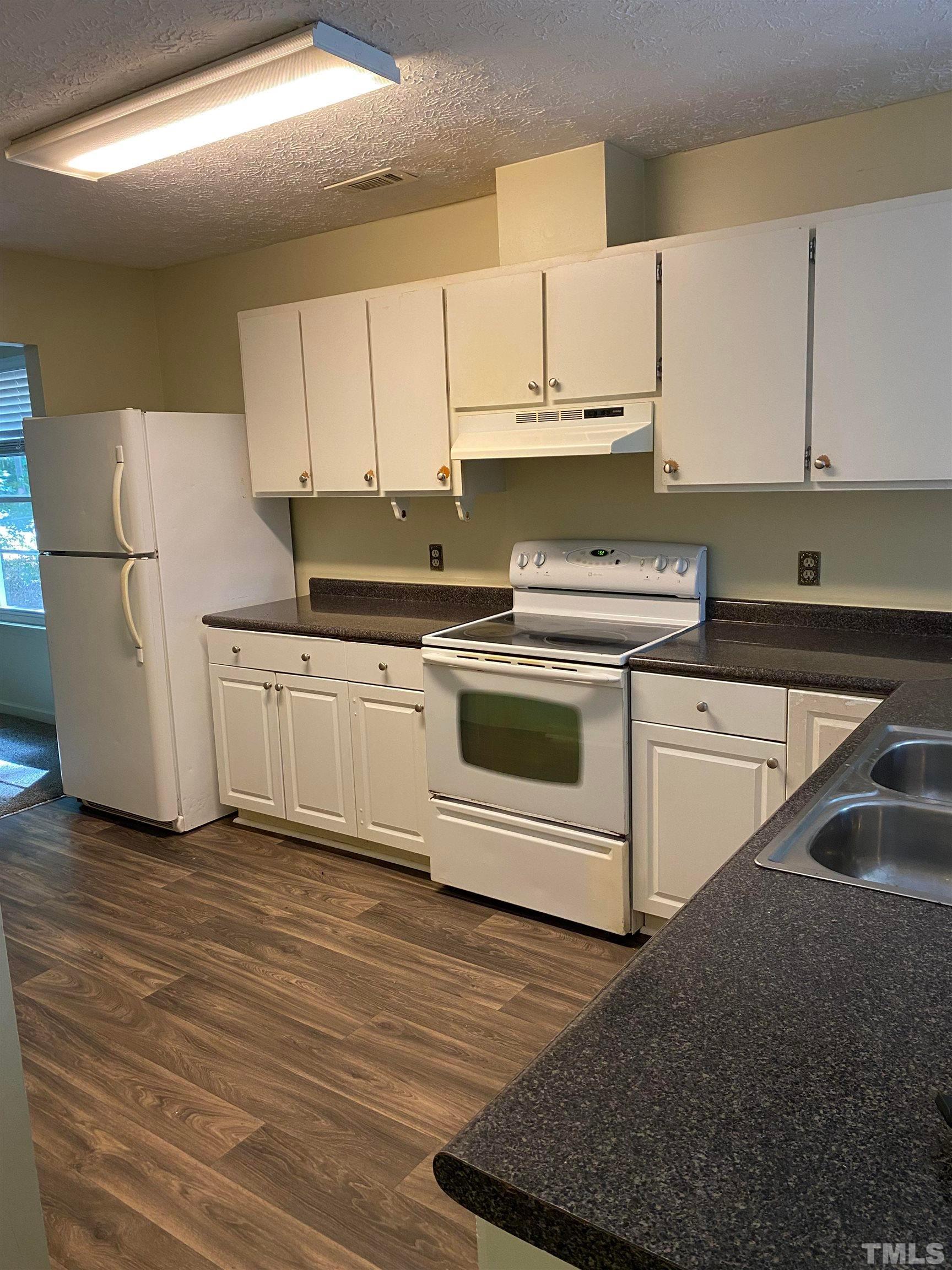 2801 Henslowe Drive Raleigh, NC 27603 - Photo 6 of 17 a kitchen with stainless steel appliances granite countertop a sink a stove a refrigerator and white cabinets