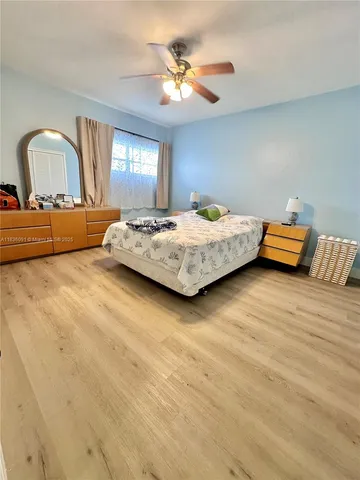 a bedroom with a bed and dresser with mirror