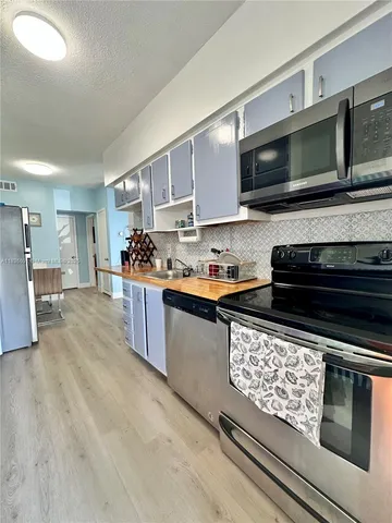 a kitchen with stainless steel appliances kitchen island granite countertop a stove and a microwave