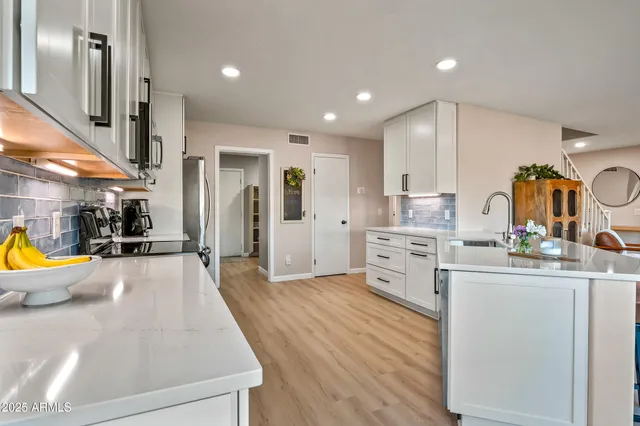 a large white kitchen with stainless steel appliances