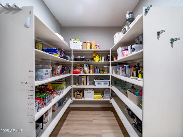 a room with lots of books and a refrigerator