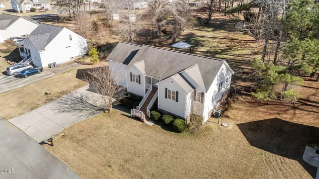 an aerial view of a house with a yard and parking space