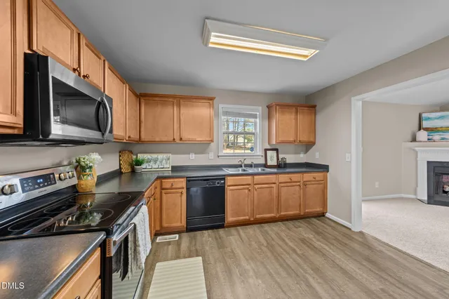 a kitchen with stainless steel appliances granite countertop a stove a sink and a microwave