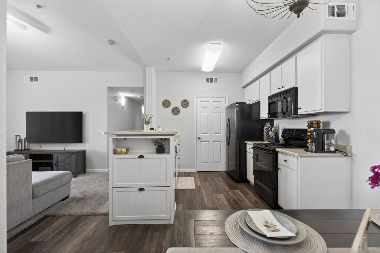 1251 Whitney Ranch Parkway, Unit 1231 Rocklin, CA 95765 - Photo 11 of 44 a kitchen with stainless steel appliances a refrigerator a stove a sink and a dining table with wooden floor