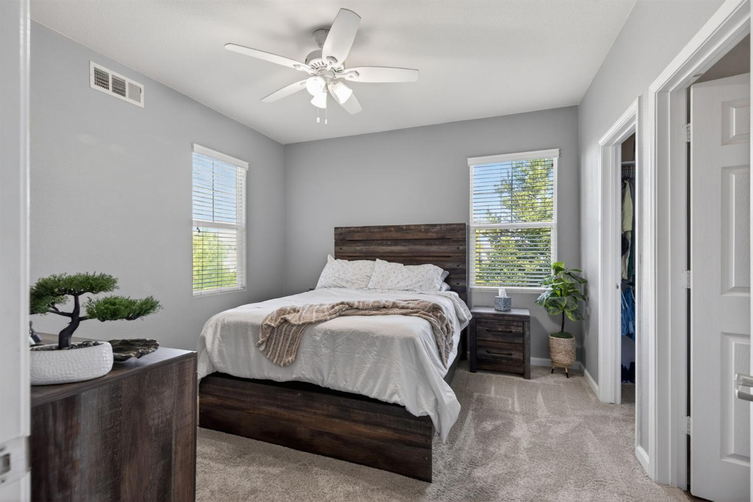 1251 Whitney Ranch Parkway, Unit 1231 Rocklin, CA 95765 - Photo 28 of 44 a bedroom with a bed table flowerpot and window