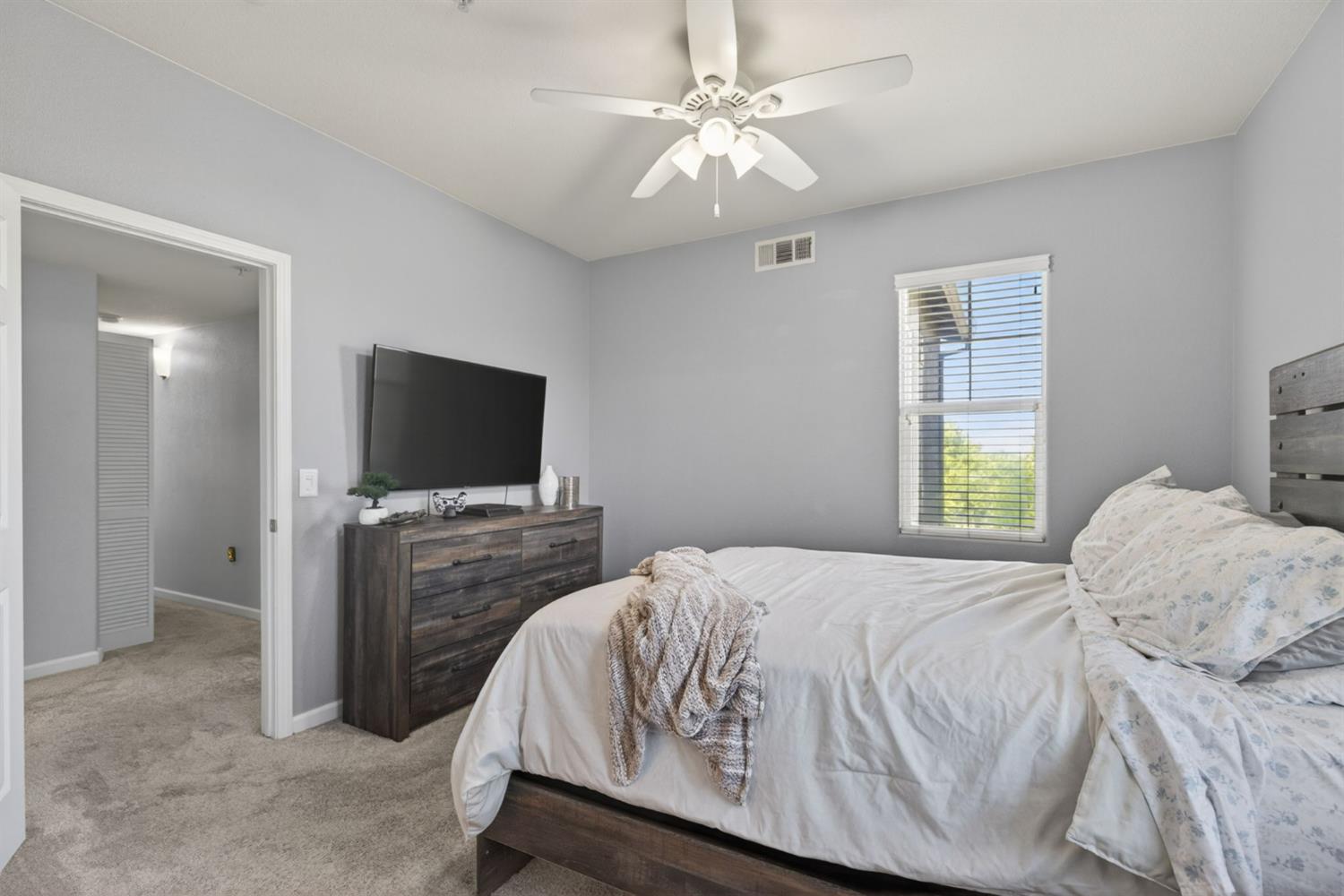 1251 Whitney Ranch Parkway, Unit 1231 Rocklin, CA 95765 - Photo 30 of 44 a bedroom with a bed and a flat screen tv