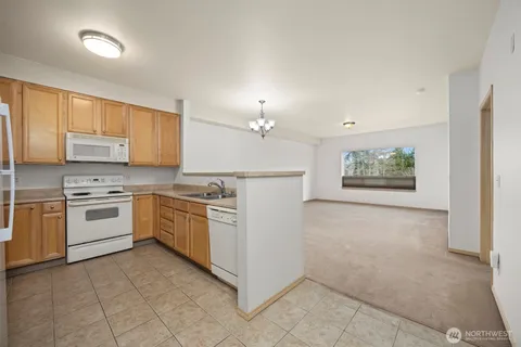 a kitchen that has a sink a refrigerator and cabinets