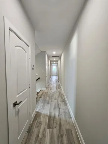 a view of a hallway with wooden floor
