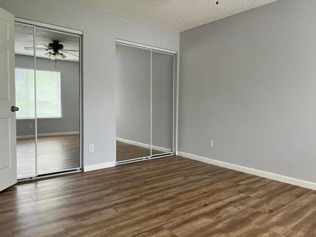 an empty room with wooden floor and closet
