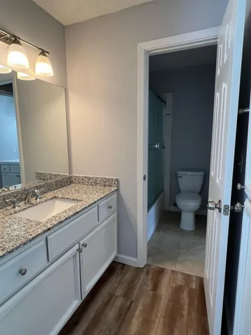 a bathroom with a granite countertop sink and toilet
