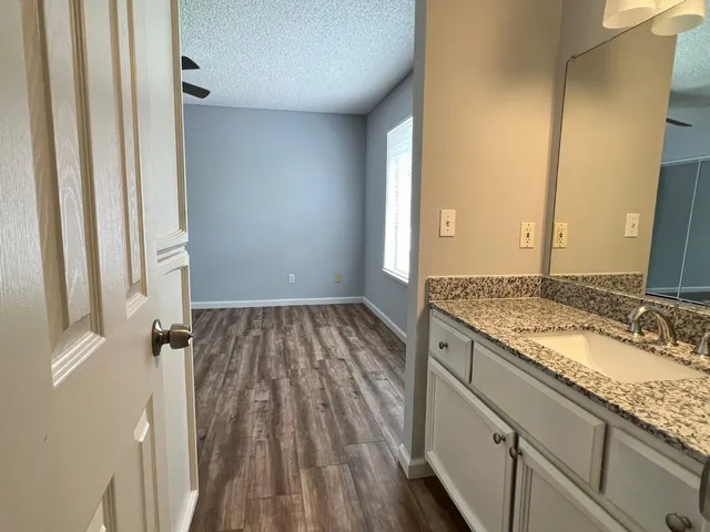 a bathroom with a granite countertop sink and a mirror