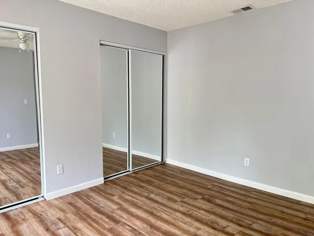 a view of empty room with wooden floor