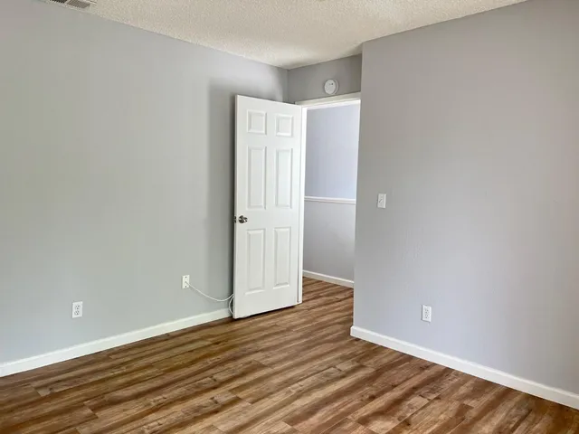 a view of an empty room with wooden floor
