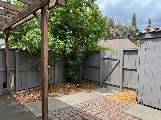 a patio with table and chairs and potted plants