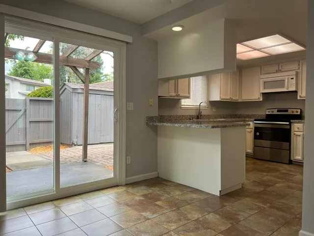 a kitchen with stainless steel appliances granite countertop a stove a sink and a refrigerator