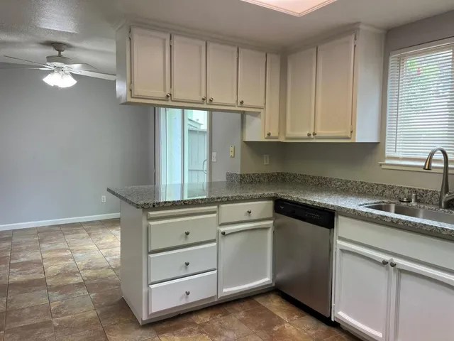 a kitchen with cabinets appliances a sink and a window