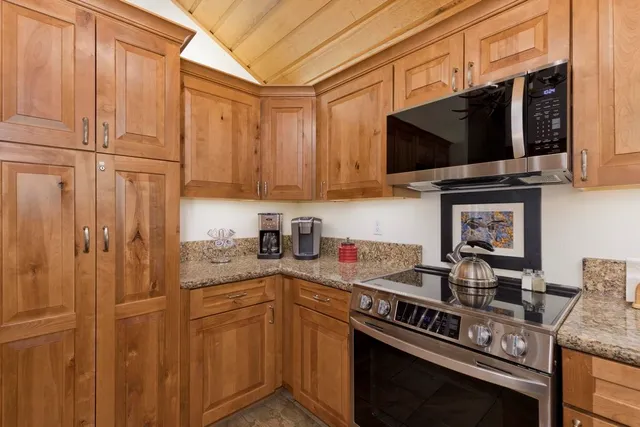 a kitchen with stainless steel appliances granite countertop a stove a sink and a microwave