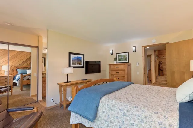 a bedroom with a bed and a flat tv screen on wall