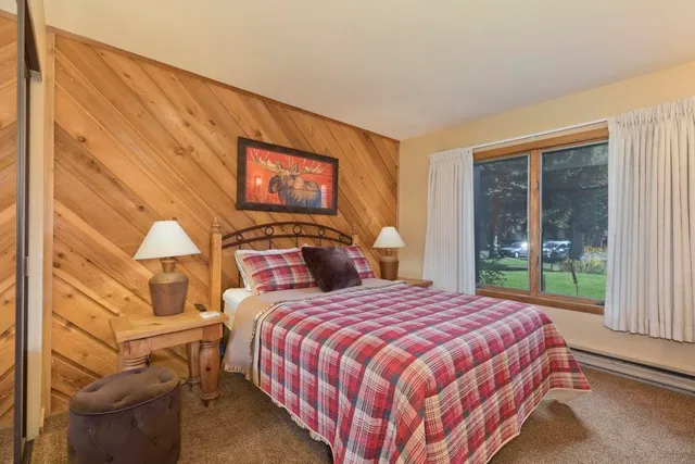 a bedroom with a bed and a painting on the wall