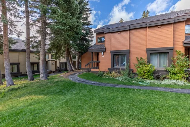 a front view of a house with a garden and plants