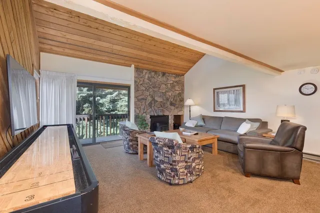 a living room with furniture a fireplace and a large window