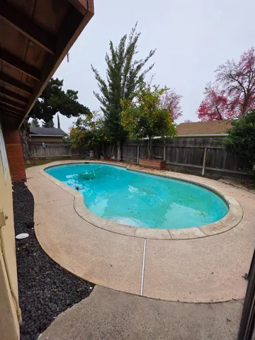 a view of a swimming pool with a yard and sitting space