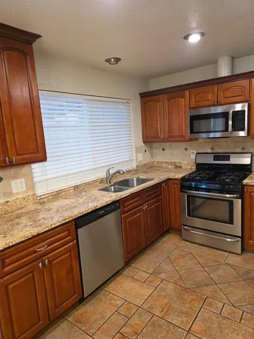 a kitchen with stainless steel appliances granite countertop a sink stove and microwave