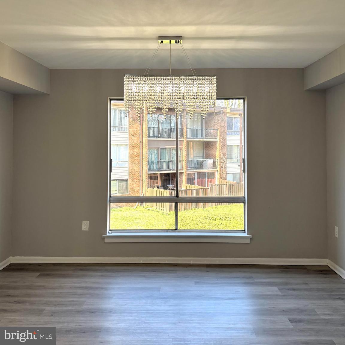 8467 Greenbelt Road, Unit 8467102 Greenbelt, MD 20770 - Photo 1 of 30 a view of an empty room with wooden floor and a window