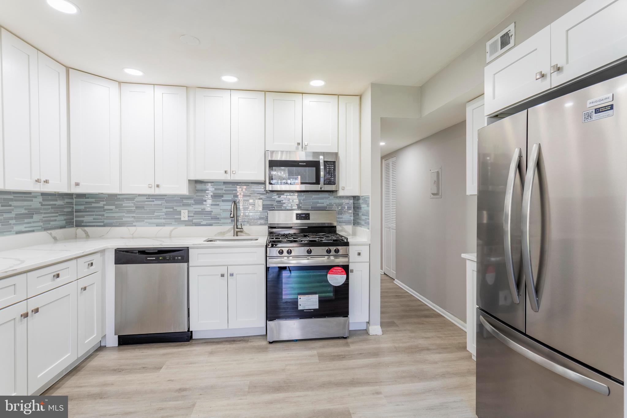8467 Greenbelt Road, Unit 8467102 Greenbelt, MD 20770 - Photo 11 of 30 a kitchen with stainless steel appliances white cabinets and a refrigerator