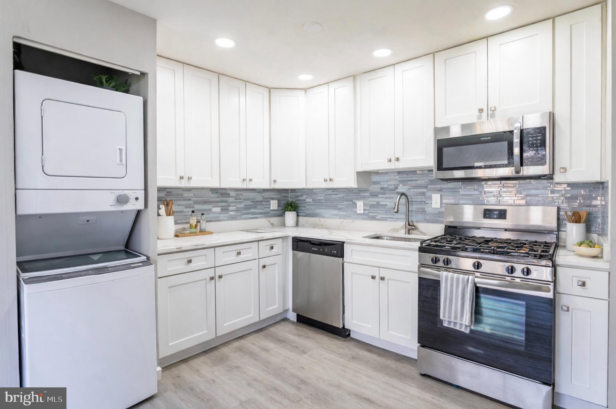 8467 Greenbelt Road, Unit 8467102 Greenbelt, MD 20770 - Photo 12 of 30 a kitchen with stainless steel appliances granite countertop a stove a sink and white cabinets