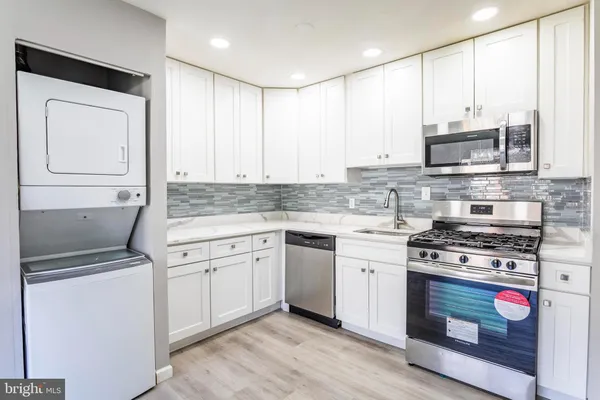a kitchen with stainless steel appliances granite countertop a stove a sink and a microwave