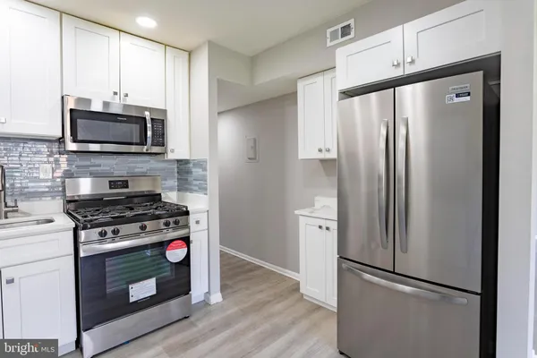 a kitchen with stainless steel appliances a refrigerator stove and microwave