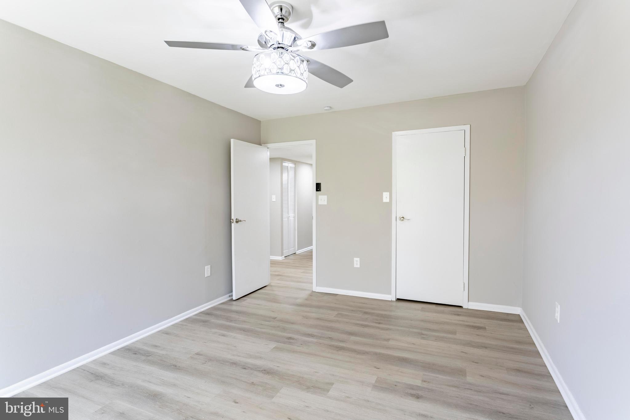 8467 Greenbelt Road, Unit 8467102 Greenbelt, MD 20770 - Photo 19 of 30 an empty room with wooden floor and ceiling fan