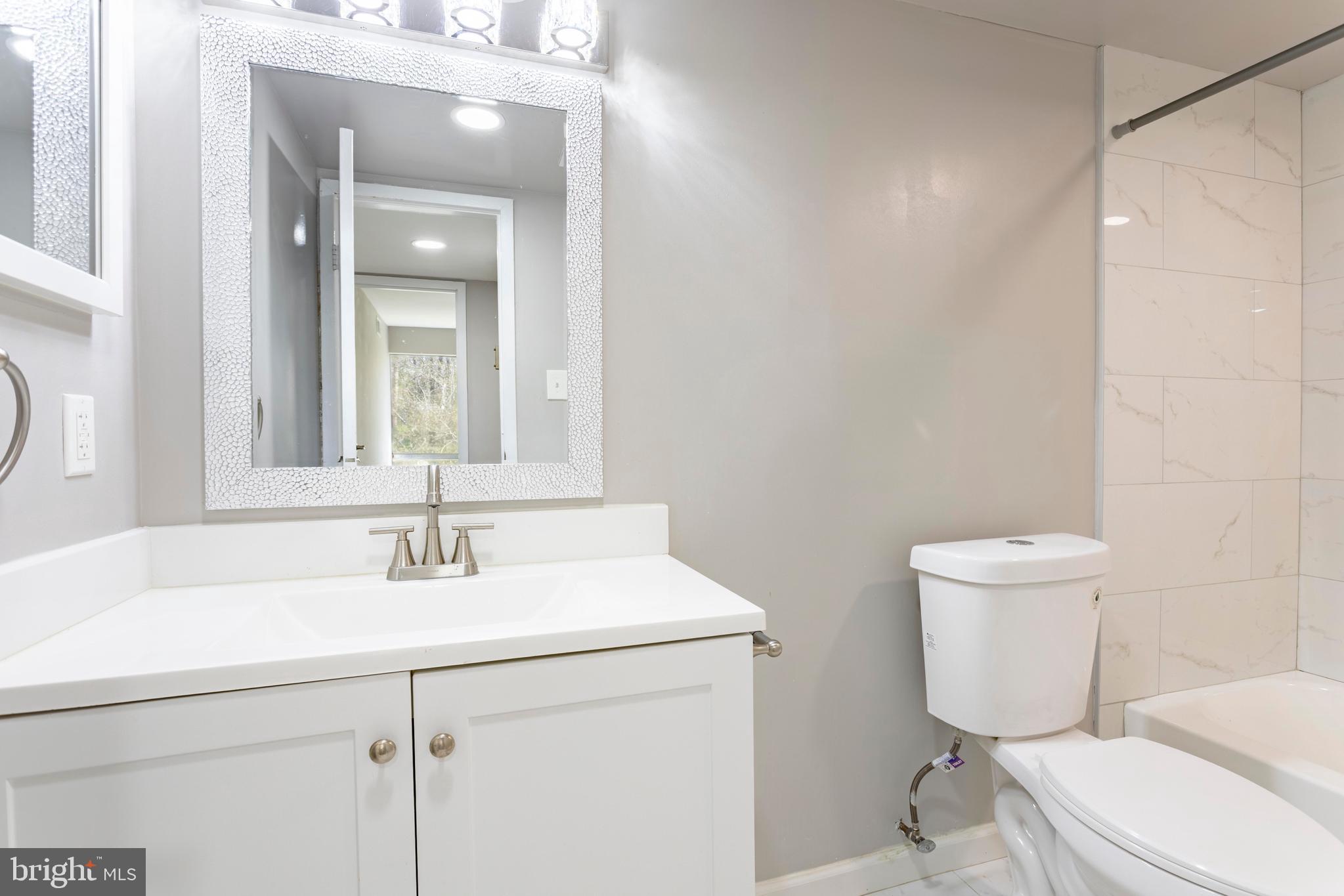 8467 Greenbelt Road, Unit 8467102 Greenbelt, MD 20770 - Photo 22 of 30 a bathroom with a toilet sink and mirror