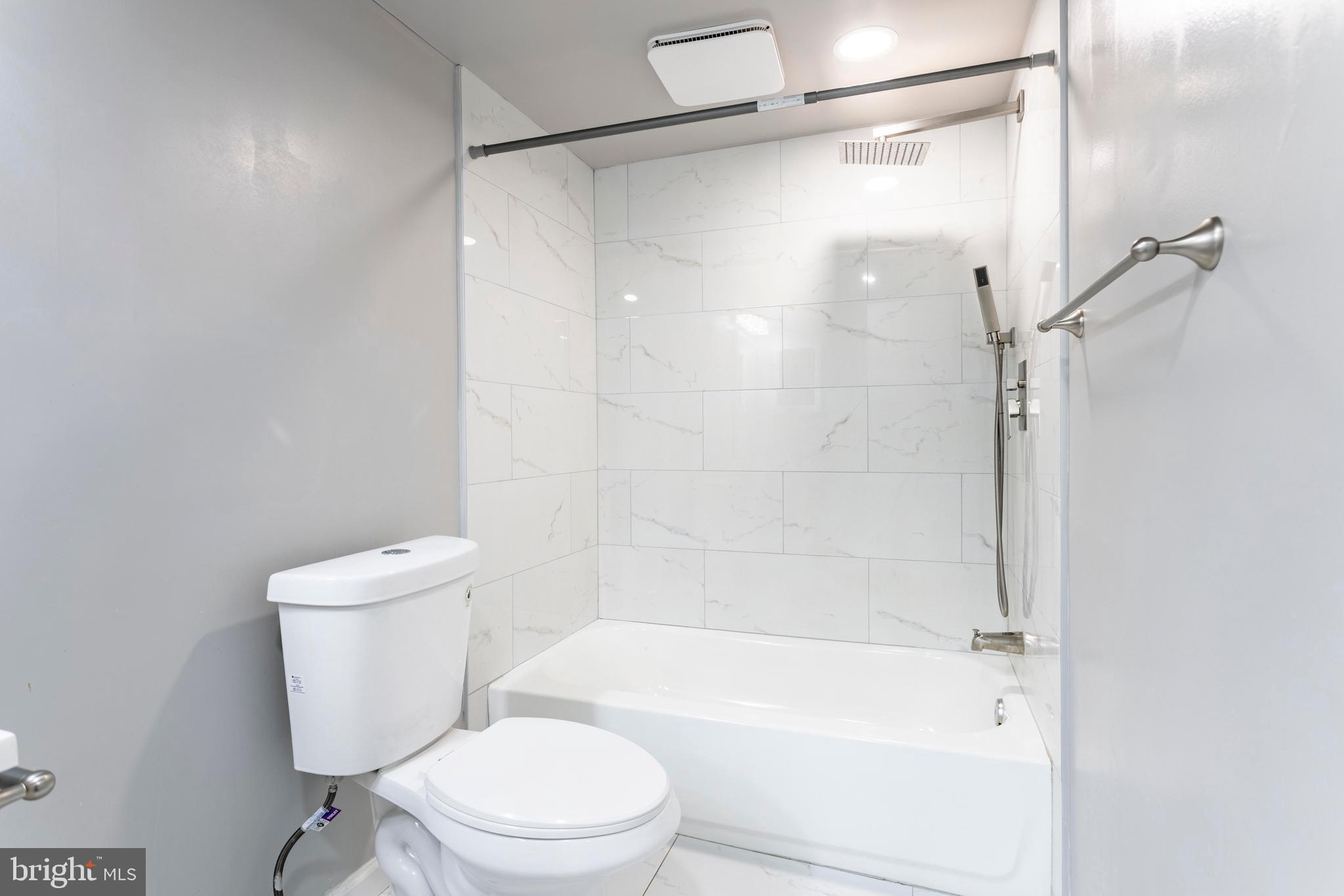 8467 Greenbelt Road, Unit 8467102 Greenbelt, MD 20770 - Photo 23 of 30 a white toilet sitting next to a bath tub and a shower