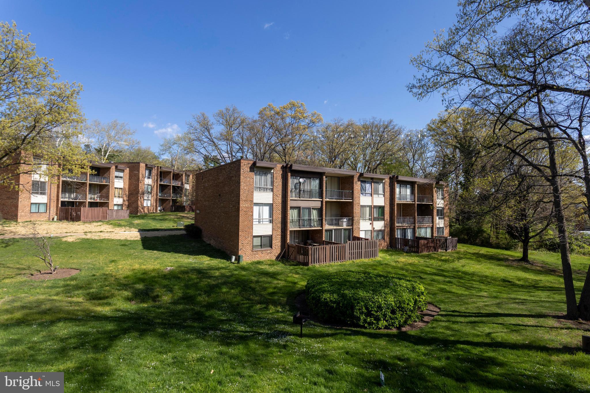8467 Greenbelt Road, Unit 8467102 Greenbelt, MD 20770 - Photo 27 of 30 a view of a house with a big yard and large trees