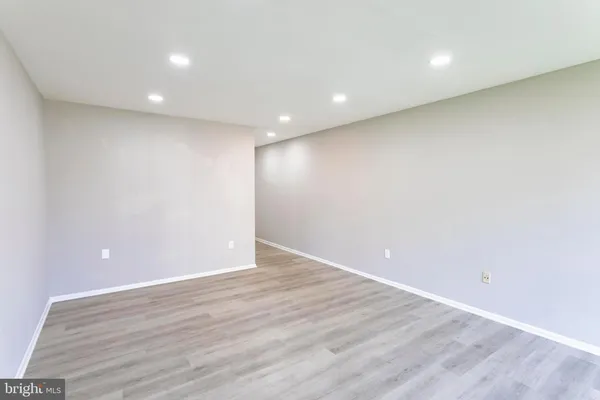 an empty room with wooden floor and entrance