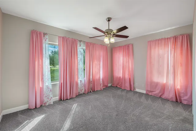 a view of a livingroom with a ceiling fan and window