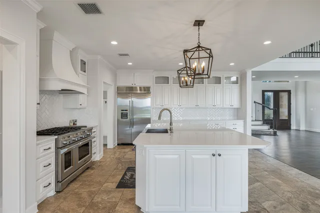 a kitchen with granite countertop a sink stainless steel appliances and cabinets