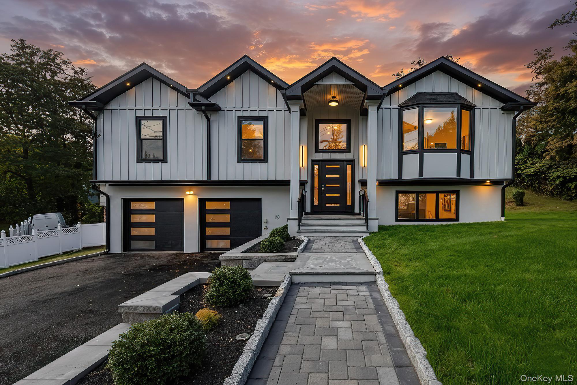 a front view of a house with a garden and yard