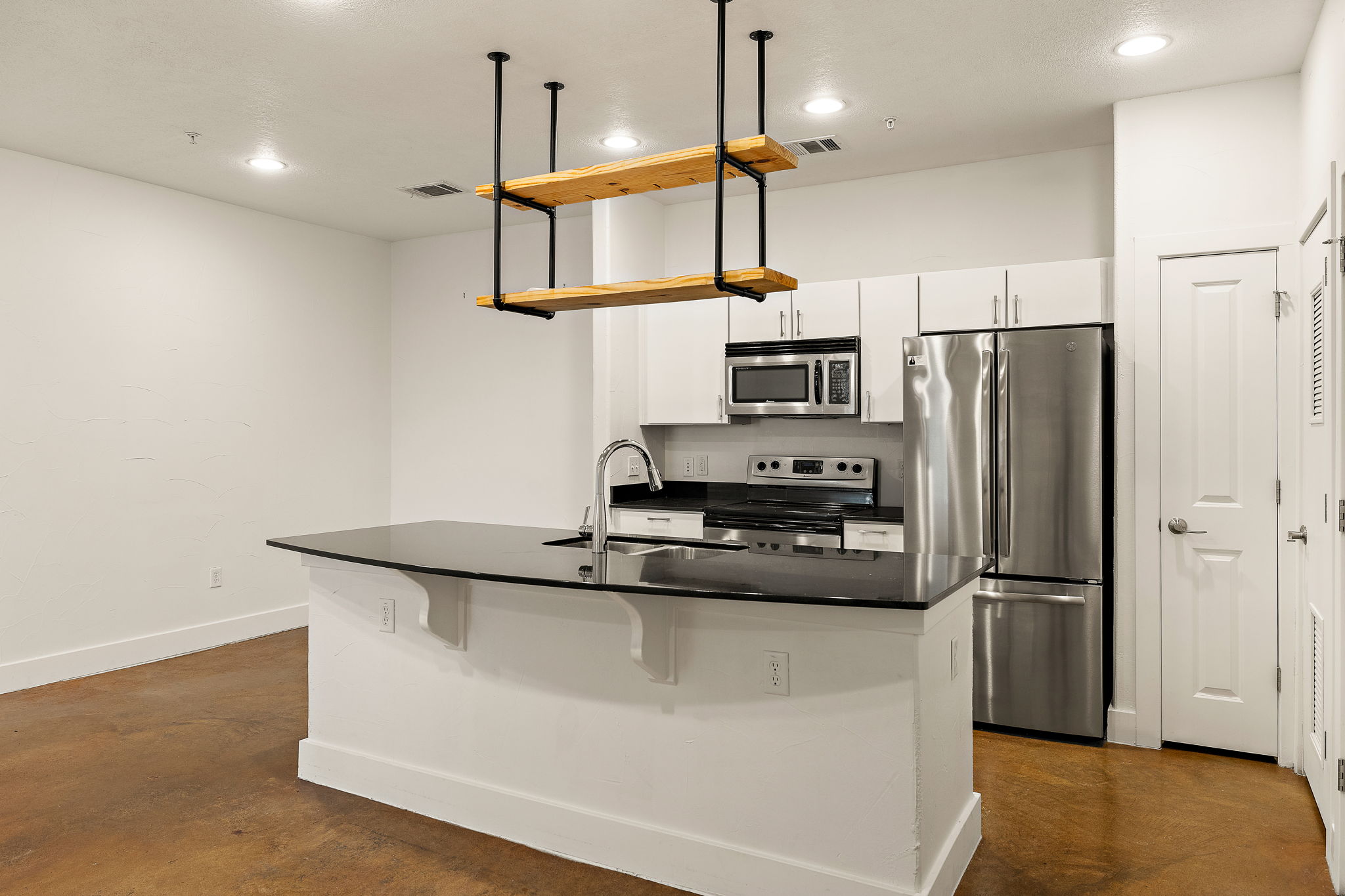 1807 Poquito Street, Unit 41 Austin, TX 78702 - Photo 10 of 23 Kitchen featuring finished concrete floors, stainless steel appliances, recessed lighting, white cabinets, and a kitchen island with sink