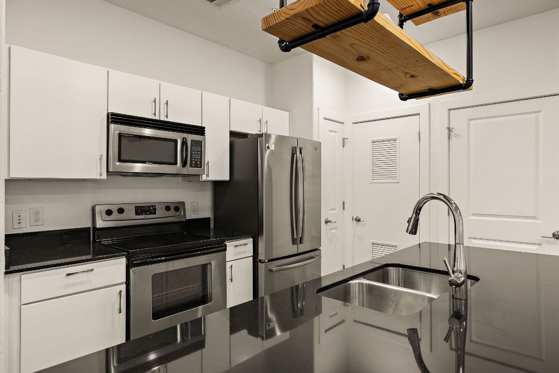 1807 Poquito Street, Unit 41 Austin, TX 78702 - Photo 11 of 23 a kitchen with stainless steel appliances a refrigerator a stove a microwave and cabinets