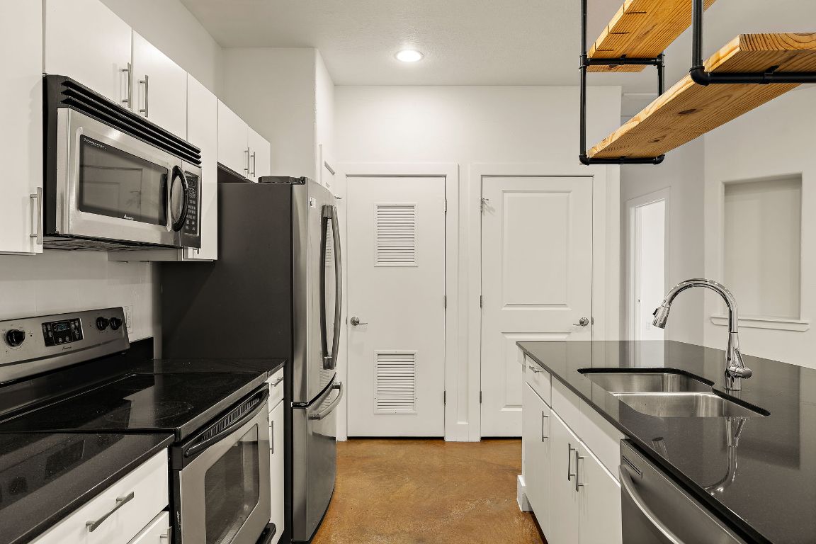 1807 Poquito Street, Unit 41 Austin, TX 78702 - Photo 12 of 23 a kitchen with stainless steel appliances granite countertop a sink stove and refrigerator